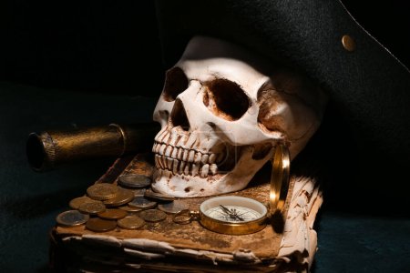 Téléchargez les photos : Crâne humain avec de vieux manuscrits, équipement de voyage, chapeau de pirate et pièces de monnaie sur fond noir - en image libre de droit