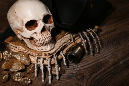 Téléchargez les photos : Crâne humain avec vieux manuscrits, matériel de voyage et pépites d'or sur fond de bois brun - en image libre de droit
