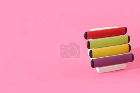Téléchargez les photos : Decorative podium with electronic cigarettes on pink background - en image libre de droit