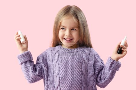Téléchargez les photos : Smiling little girl with nasal drops on pink background - en image libre de droit