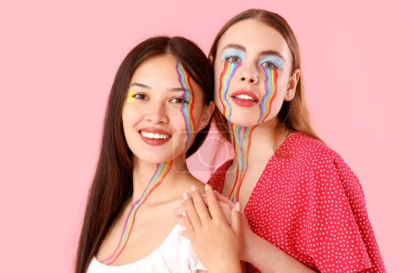 Téléchargez les photos : Jeunes femmes avec des visages peints étreignant sur fond rose, gros plan - en image libre de droit