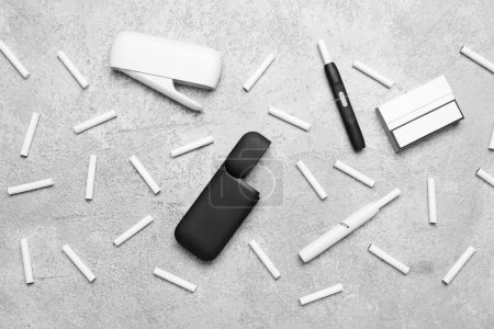 Téléchargez les photos : Composition avec cigares électroniques modernes et bâtons sur table grunge grise - en image libre de droit