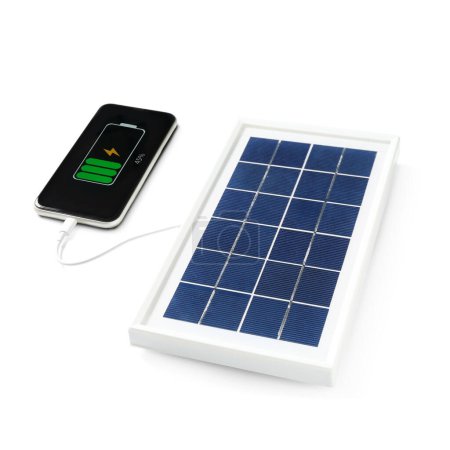 Foto de Portable solar panel charging mobile phone on white background - Imagen libre de derechos