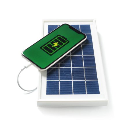 Foto de Portable solar panel with charged mobile phone on white background - Imagen libre de derechos