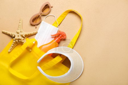 Téléchargez les photos : Sac avec bouteille de crème solaire, masque médical et accessoires de plage sur fond de couleur. Concept de mélanome - en image libre de droit
