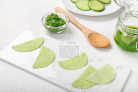 Photo for Board with cotton under-eye patches made of cucumber on white table, closeup - Royalty Free Image