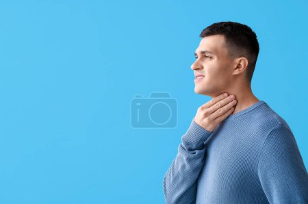 Photo for Young man with thyroid gland problem on blue background - Royalty Free Image