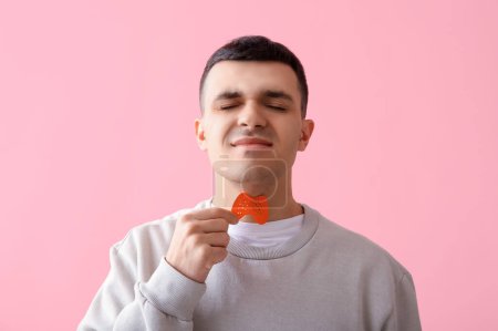 Photo for Young man with paper thyroid gland on pink background, closeup - Royalty Free Image