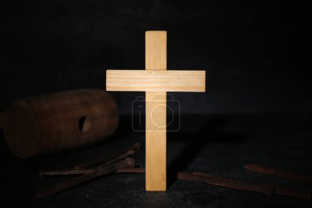Photo for Wooden cross with nails and mallet on dark background, closeup. Good Friday concept - Royalty Free Image