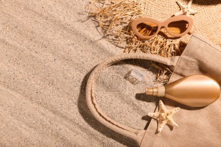 Téléchargez les photos : Composition avec bouteille de crème solaire et accessoires de plage sur sable. Concept de mélanome - en image libre de droit