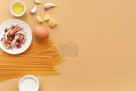 Foto de Ingredientes para una sabrosa pasta carbonara sobre fondo beige - Imagen libre de derechos