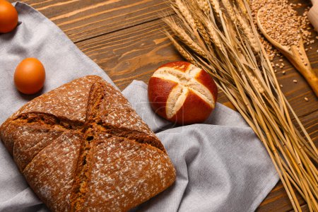 Photo for Different types of bread and wheat ears on wooden table - Royalty Free Image