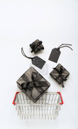 Foto de Cesta de la compra con cajas de regalo sobre fondo blanco. Concepto Viernes Negro - Imagen libre de derechos