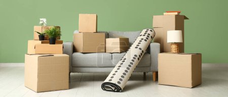 Photo for Sofa with rolled carpet and cardboard boxes in living room on moving day - Royalty Free Image