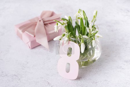Téléchargez les photos : Vase avec de belles gouttes de neige, numéro 8 et boîte cadeau sur fond gris grunge - en image libre de droit