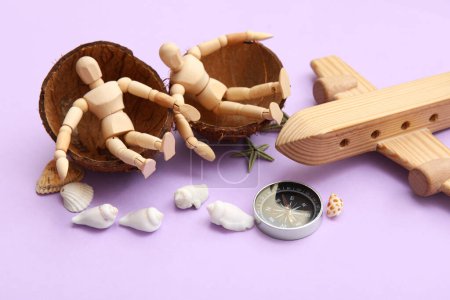 Téléchargez les photos : Composition avec plan en bois, boussole et mannequins assis en coco sur fond lilas - en image libre de droit