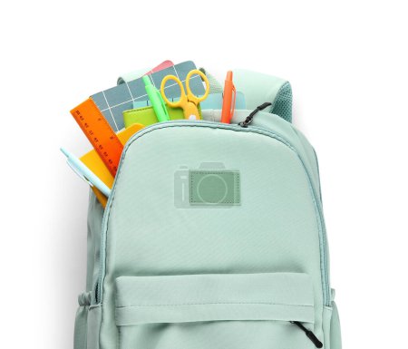 Foto de Elegante mochila escolar azul con diferentes artículos de papelería sobre fondo blanco - Imagen libre de derechos