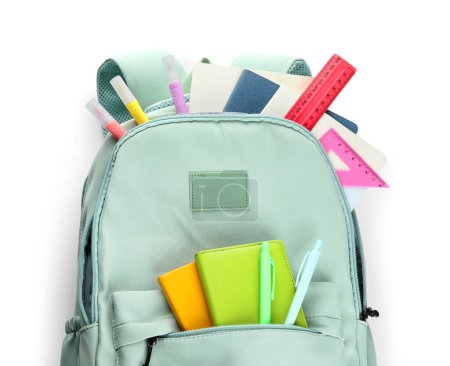 Foto de Elegante mochila escolar azul con diferentes artículos de papelería sobre fondo blanco - Imagen libre de derechos