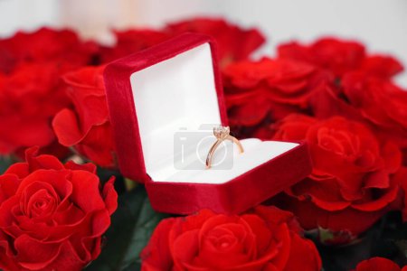 Foto de Caja con anillo de compromiso en ramo de rosas, primer plano. Celebraciones del Día de San Valentín - Imagen libre de derechos