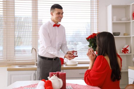 Foto de Joven proponiéndole matrimonio a su novia en la cocina. Celebración de San Valentín - Imagen libre de derechos