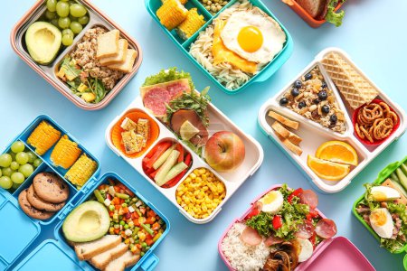 Viele Lunchboxen mit verschiedenen leckeren Speisen auf blauem Hintergrund