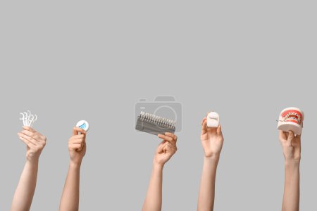 Photo for Female hands with dental floss, shade guide and jaw model on grey background - Royalty Free Image