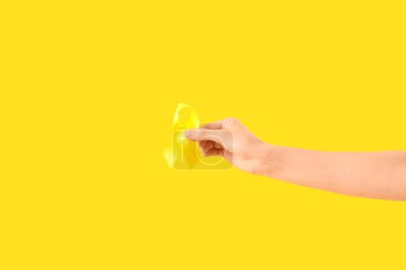 Téléchargez les photos : Femme avec ruban de sensibilisation jaune sur fond de couleur, gros plan - en image libre de droit