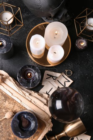 Téléchargez les photos : Les attributs magiques de la sorcière avec des bougies allumées sur fond sombre - en image libre de droit