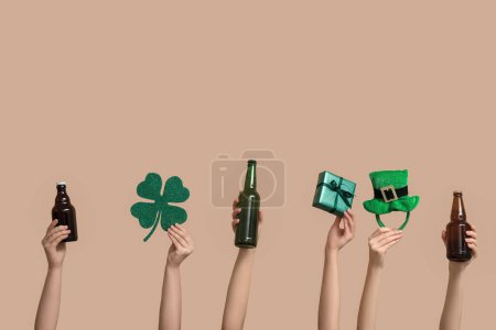 Photo for Many hands with beer, gift and party decorations on beige background. St. Patrick's Day celebration - Royalty Free Image