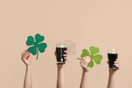 Photo for Hands with beer and clover on beige background. St. Patrick's Day celebration - Royalty Free Image