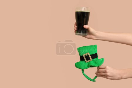 Photo for Hands with beer and party decor in shape of leprechaun's hat on beige background. St. Patrick's Day celebration - Royalty Free Image