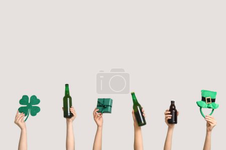 Photo for Hands with beer, gift and party decor on light background. St. Patrick's Day celebration - Royalty Free Image