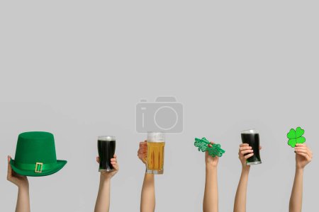 Photo for Hands with beer and party decor on light background. St. Patrick's Day celebration - Royalty Free Image