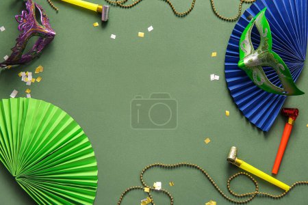 Téléchargez les photos : Cadre fait de masques de carnaval avec cornes de fête et décor pour la célébration de Mardi Gras sur fond vert - en image libre de droit
