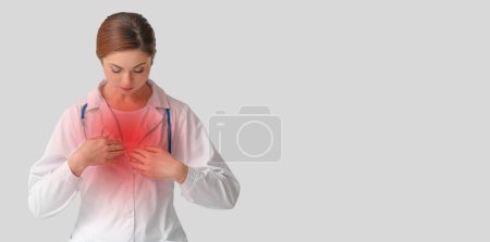 Photo for Female doctor feeling discomfort in chest on light background with space for text - Royalty Free Image