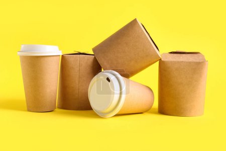 Foto de Tazas y cajas de papel para llevar sobre fondo amarillo - Imagen libre de derechos