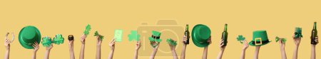 Photo for Many hands with beer, gifts and decor on yellow background. St. Patrick's Day celebration - Royalty Free Image