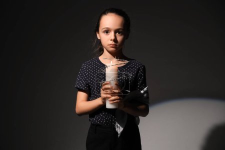 Petite fille juive avec une bougie allumée sur fond sombre. Journée internationale de commémoration de l'Holocauste
