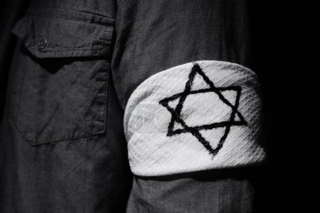 Jeune homme juif avec brassard sur fond noir, gros plan. Journée internationale de commémoration de l'Holocauste