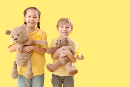 Photo for Cute little children with yellow ribbons and teddy bears on color background. Childhood cancer awareness concept - Royalty Free Image
