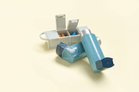 Téléchargez les photos : Inhalateurs d'asthme avec étui à pilules sur fond jaune - en image libre de droit