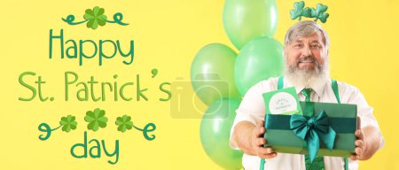 Photo for Funny bearded man with gift and balloons on yellow background. Banner for St. Patrick's Day - Royalty Free Image