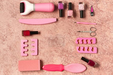 Foto de Conjunto de herramientas profesionales para pedicura con esmaltes de uñas sobre fondo rosa grunge - Imagen libre de derechos