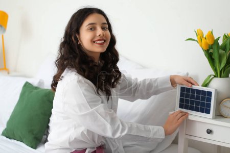 Foto de Chica adolescente con panel solar portátil en el dormitorio - Imagen libre de derechos