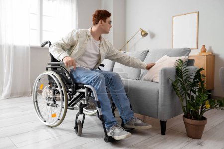 Foto de Joven en silla de ruedas con cojín en el sofá en casa - Imagen libre de derechos