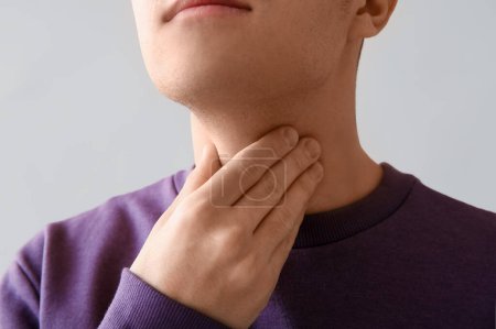 Photo for Young man with thyroid gland problem on light background, closeup - Royalty Free Image