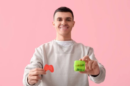 Photo for Young man with paper thyroid gland and pill box on pink background - Royalty Free Image