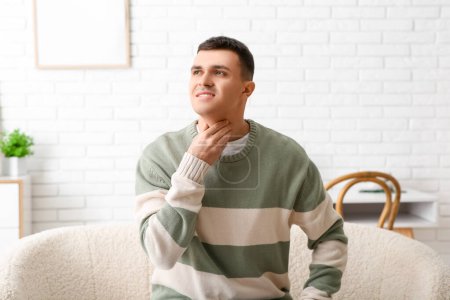 Photo for Young man with thyroid gland problem at home - Royalty Free Image