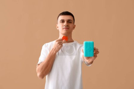 Photo for Young man with paper thyroid gland and pill box on beige background - Royalty Free Image