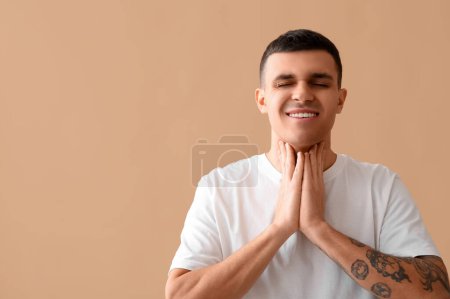 Photo for Young man with thyroid gland problem on beige background - Royalty Free Image